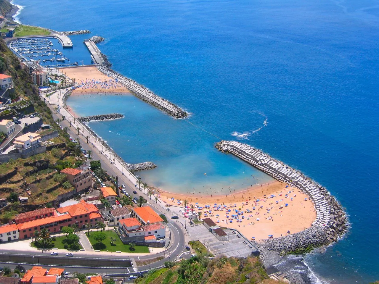 Two sandy bathing areas and breakwaters beside Calheta marina